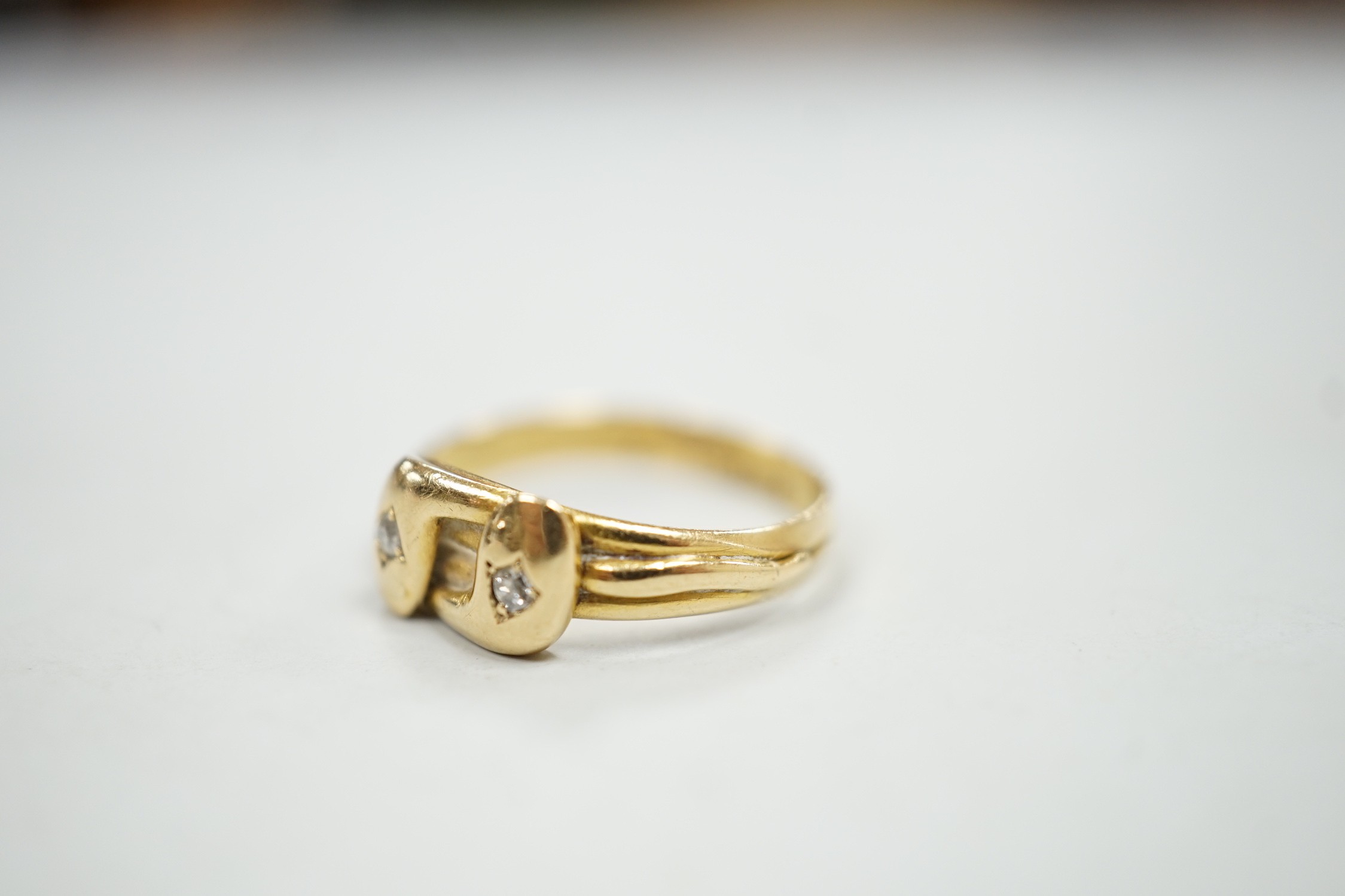 A late Victorian 18ct gold and two stone diamond set twin serpent ring, size L, gross weight 2.6 grams.